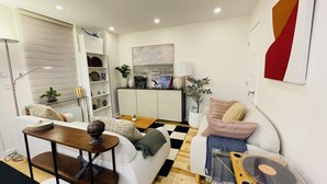 En moderne stue med sofa, sofabord og reol.