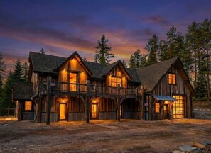 A large wooden cabin with multiple levels, a balcony, and a garage. - New! Spacious Lodge | 3 Kings | Hot Tub & Fire Pit (Whitefish)