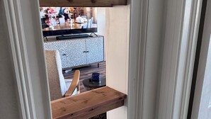 Eine schmale Treppe mit einer Holzhandläufe, die zu einem Essbereich führt.