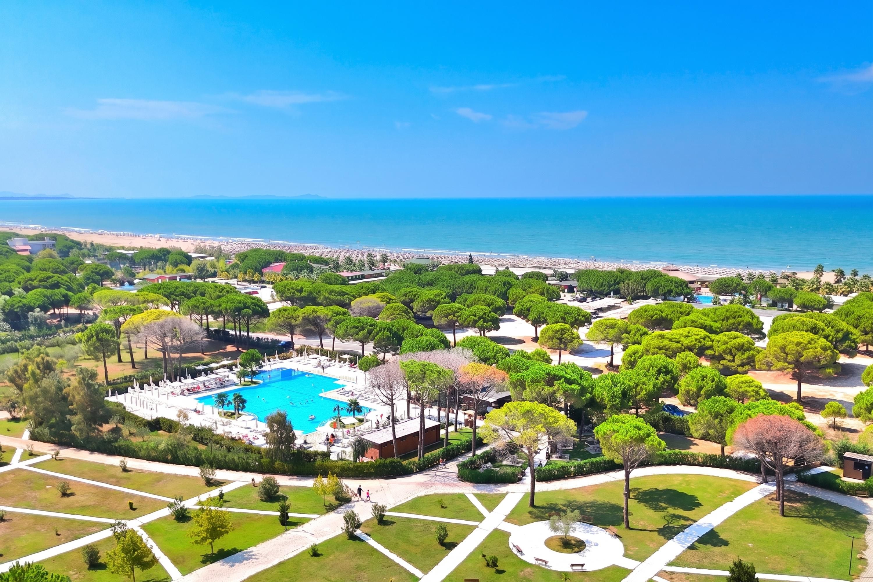 Ein Resort mit Schwimmbad, umgeben von gepflegten Gärten und Blick auf das Meer.