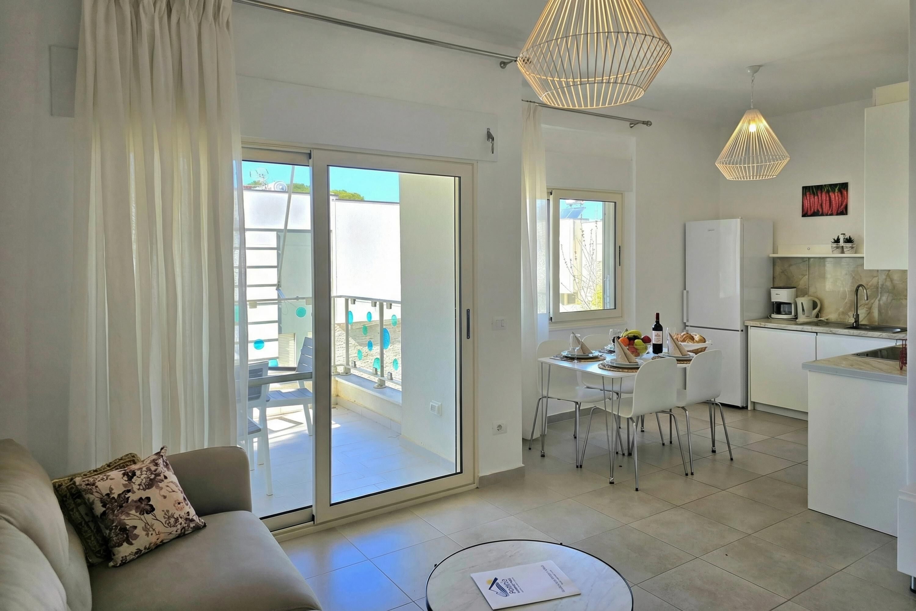 A modern apartment with a living room, dining area, kitchen, and a balcony.