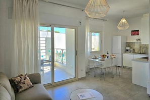 Apartamento moderno com sala de estar, área de refeições, cozinha e varanda.