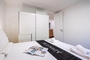 A hotel room with a bed, a magazine, a towel, and a wardrobe. - Luxury City Penthouse Adialuxe S7, Rijeka, Croatia (Rijeka)