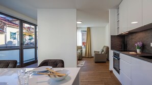 A modern kitchen with a dining area, large windows, and a view of the outside. - Luxury City Penthouse Adialuxe S7, Rijeka, Croatia (Rijeka)