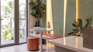 A modern interior with a glass table, a bench, and potted plants. - CityHouse NEST Bellita (Ho Chi Minh City)