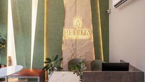 A reception desk with a marble top, a plant, and a wall-mounted air conditioning unit. - CityHouse NEST Bellita (Ho Chi Minh City)