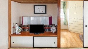 A traditional Japanese room with tatami flooring, a low wooden desk with a television, a framed picture on the wall, and a fish decoration above the desk. - High-quality Japanese modern private accommodation! Experience staying in a shopping district! Japanese/Western style room & bed! Good access to Disney! Free parking! (Shimoshinozakimachi, Edogawa City)