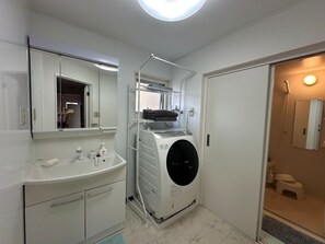 Een haardroger, handdoeken, zeep, toiletpapier