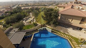 Ein Pool auf dem Dach mit Blick auf ein Wohngebiet und einen angelegten Garten.