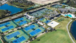 An aerial view of a golf course with multiple tennis courts, a swimming pool, and a large lawn area. - Golf Course Views | Upscale Studio | Wesley Chapel | Sleeps 2, Pickleball Included | Saddlebrook (Zephyrhills)