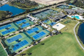 An aerial view of a golf course with multiple tennis courts, a swimming pool, and a large lawn area. - Upscale Golf Retreat | Fairway Views & Optional Resort Amenities | Saddlebrook (Zephyrhills)