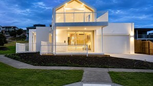 A modern two-story house with a balcony, a visible staircase, and a well-lit entrance. - The White Nest by Ready Set Stay (San Remo)