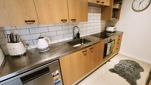 Una cucina moderna con mobili in legno, un lavello in acciaio inossidabile e una lavastoviglie.