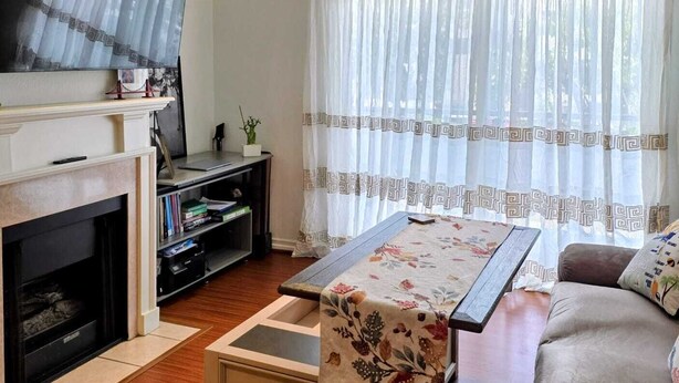 A living room with a fireplace, a sofa, a coffee table, and a television.