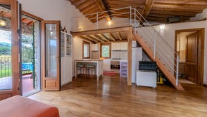 Ein großzügiger Wohnbereich im Loft-Stil mit Küche, Essbereich und einer Treppe zu einer erhöhten Ebene.