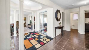 A spacious hallway with white walls, a patterned rug, and a large mirror. - 4 Tvs, King Bed, Across Recreational Park, Tennis Court, Near Commercial Center (Ajax)