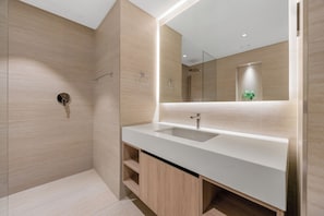 A modern bathroom with a large mirror, a sink, and a shower. - Modern Apartment with Rooftop Amenities (Dubai)