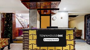 Ein Empfangsbereich mit einem Schild, auf dem 'Townhouse Oak' und 'Company-Serviced' stehen.