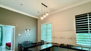 A modern kitchen with a black countertop, a built-in oven, and a window with blinds. - Homestay Selesa KKT Guesthouse (Kuala Terengganu)