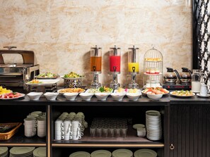 Un aparador tipus buffet amb diversos plats, begudes i una estació de cafè.