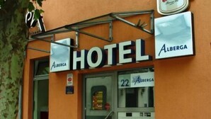 En hotellentrédörr med en skylt som visar texten ”HOTEL ALBERGA” och ett rumsnummer, ”22”.
