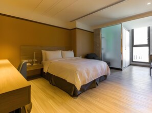 Quarto de hotel moderno com cama, mesa de cabeceira, luminária e vista para o exterior.