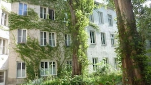 A building with multiple windows, surrounded by greenery and trees. - Govienna Small Modern Apartment (Vienna)