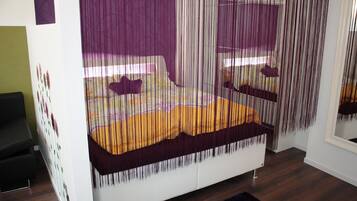 Un dormitorio moderno con una cama, una mesita de noche y un espejo.