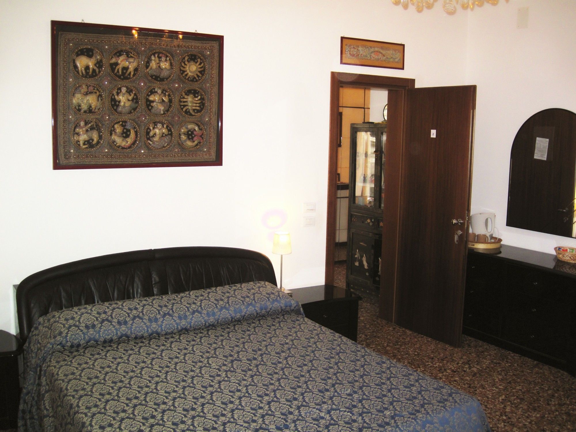 Un dormitorio con cama, un adorno en la pared, una puerta y un aparador.