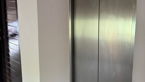 A modern elevator with a metallic finish, a visible floor indicator, and a door with a black handle. - Sitara Hotel Patong Beach (Patong)