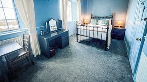 A bedroom with a bed, bedside table, dresser, and a window with curtains. - Rock House Hotel - Guest House (Lynmouth)