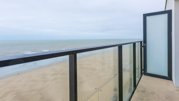 Un balcón con vista a la playa y al océano.