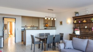 Eine moderne Küche mit Kochinsel, Essbereich mit Stühlen und einer Couch.