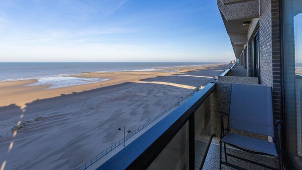 Ein Balkon mit Blick auf Strand und Meer.