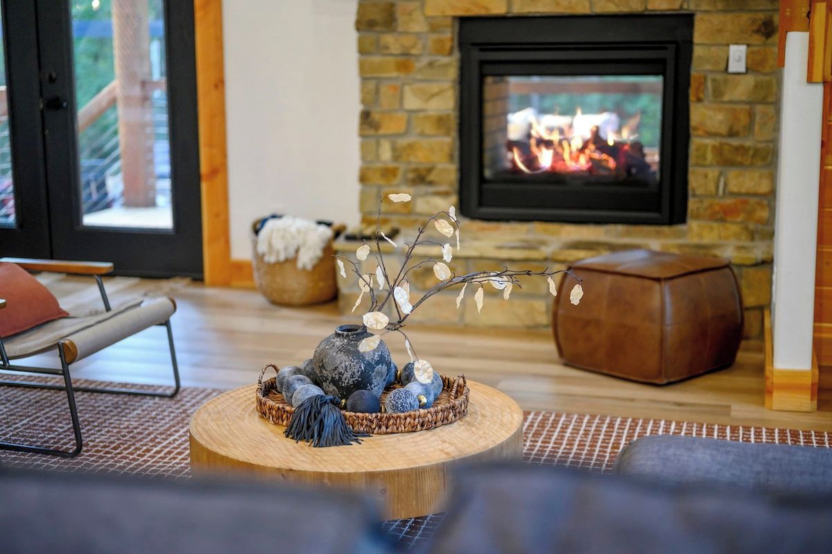 Cozy stone fireplace and curated living room decor at Hochatown Oklahoma luxury cabin rental