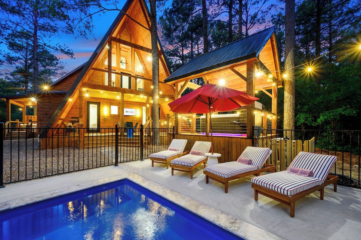 Private pool with lounge chairs and string lights at A-frame cabin in Broken Bow Oklahoma