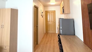 Una cucina moderna con mobili in legno, un tavolo da pranzo e un frigorifero.