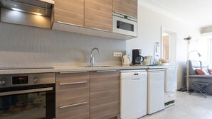 Une cuisine moderne avec des meubles en bois, des appareils électroménagers en acier inoxydable et un four encastré.