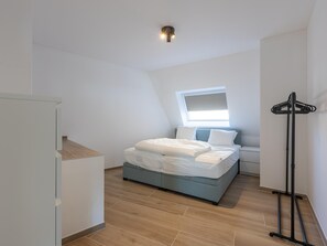 A bedroom with a bed, a window, and a coat rack. - Spacious apartment with 3bedrooms close to  sea (Middelkerke)