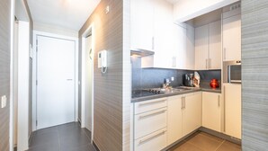 Een moderne keuken met witte kastjes, een zwart aanrecht en een fornuis.