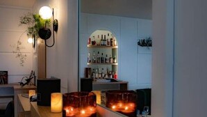 Zona de bar con mostrador de madera, velas y un espejo que refleja el bar.