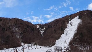 A snow-covered mountain landscape with ski lifts and a clear sky. - Izumigo Takayama Dog Paradise Hotel (Takayama)