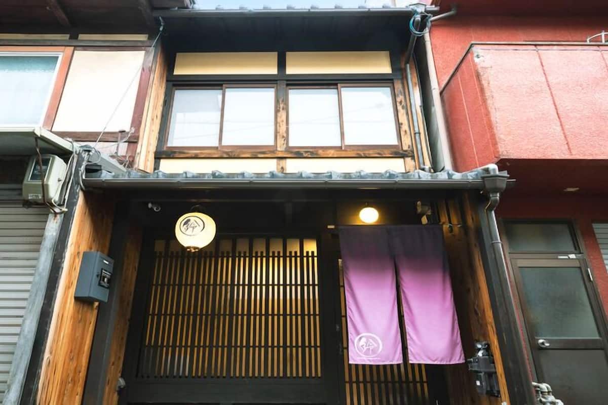 Ein traditionelles japanisches Gebäude mit Holzbeschichtung, einer Schiebetür und einer kleinen Laterne.