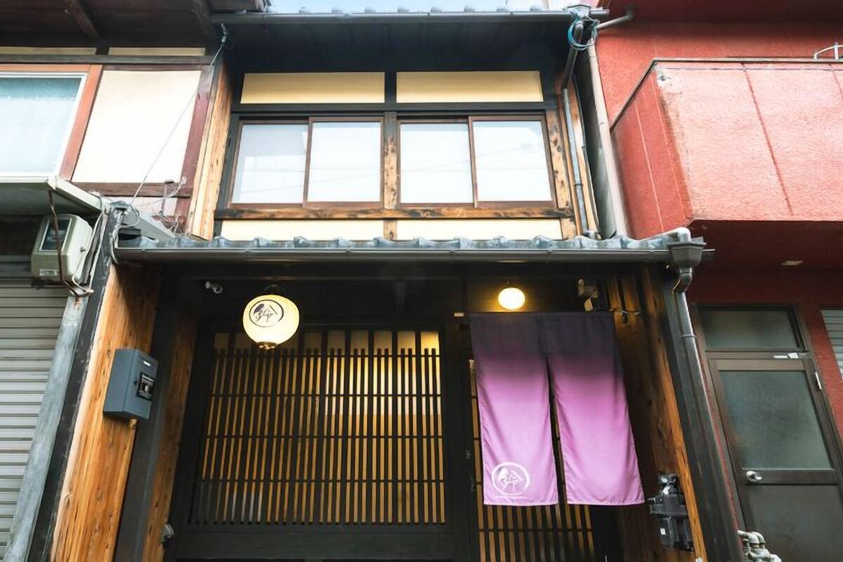 A traditional Japanese building with a wooden facade, a sliding door, and a small lantern.