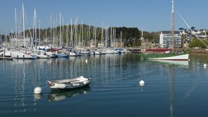 A marina with various boats docked, calm water, and a building in the background. - Ground Floor Holiday Home in Plestin des Greves (Plestin-les-Greves)