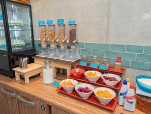Disposición de un bufé de desayuno con diferentes alimentos y acompañamientos.