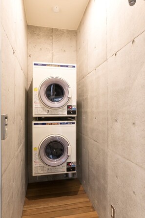 A laundry room with two stacked front-loading washing machines. - The Breakfast Hotel Porto Ishigaki (Ishigaki)