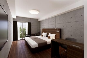 Quarto de hotel moderno com uma cama grande, uma escrivaninha e vista para o exterior.