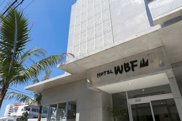 A modern hotel entrance with a sign reading "HOTEL WBF". - THE Breakfast Hotel Porto Ishigaki (Ishigaki)