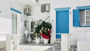 A white room with a blue door, a potted plant, and a tiled floor. - Studios Taki's Place (Naxos)